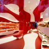 Rénovation d'un magasin de chaussures de camping-car rouge et blanc courbé par A-cero