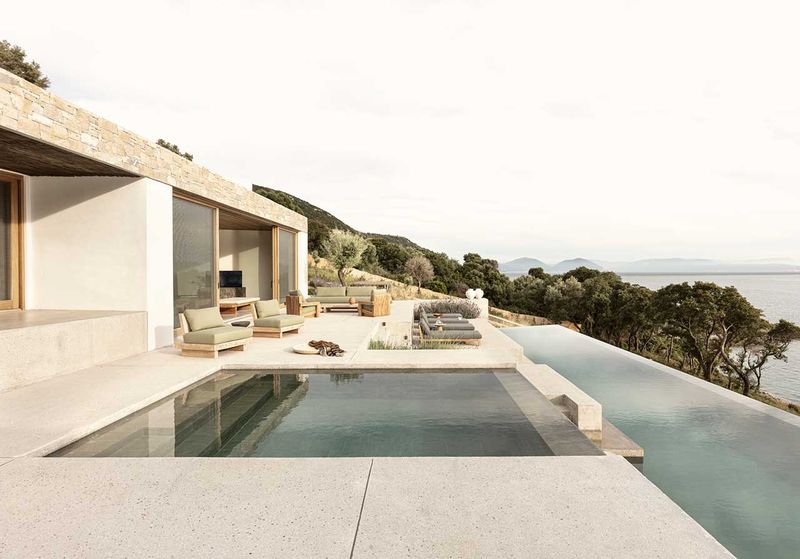 Une villa grecque moderne construite à flanc de falaise surplombant la mer